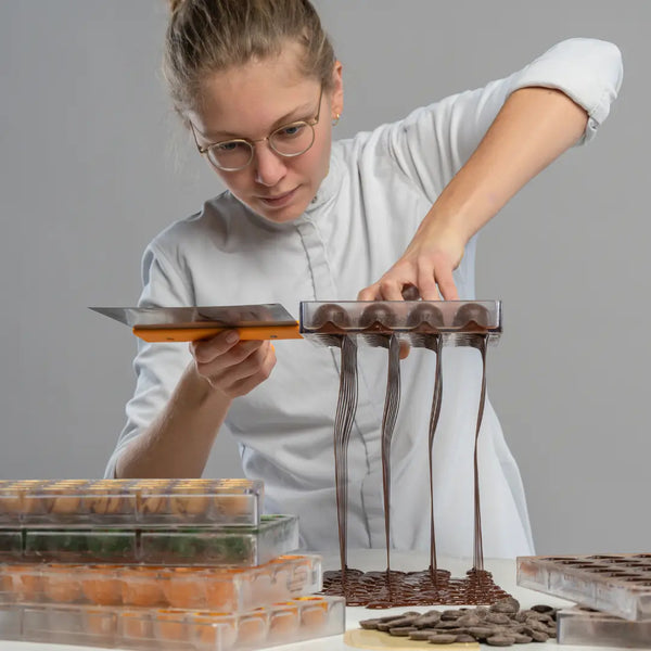 Elena gießt Pralinenformen in der Manufaktur
