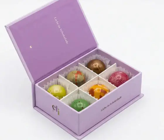 Geöffnete ELI-Box in Flieder mit sechs handbemalten Pralinen